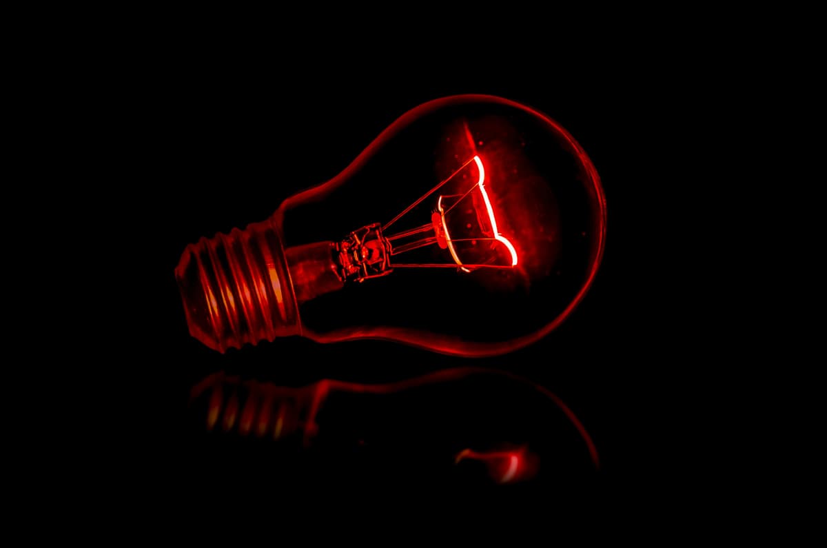 Image of a red light bulb with a black background